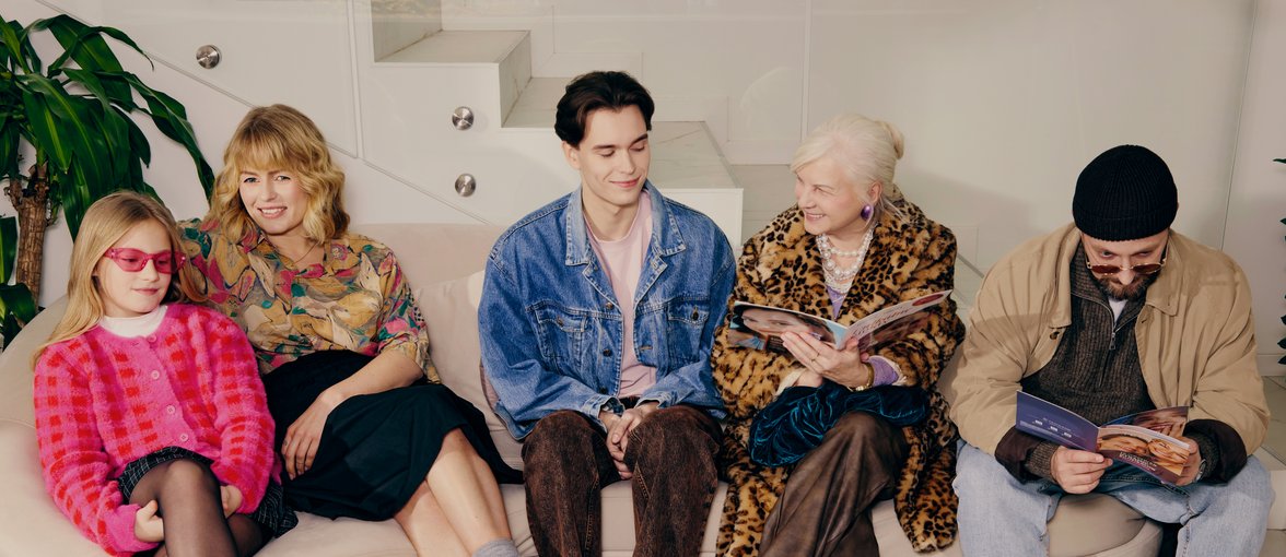 Osoby w różnym wieku, siedzące na kanapie w poczekalni.