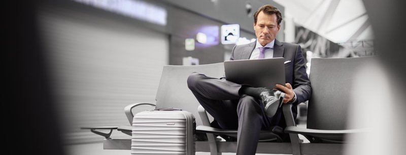 mężczyzna na lotnisku pracuje na laptopie