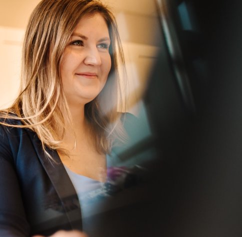 Kobieta lat 40 pracuje, przed komputerem