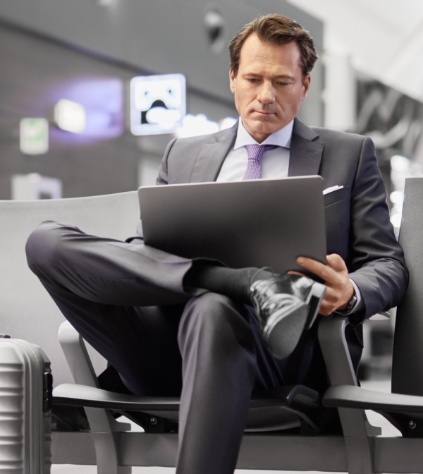 Mężczyzna siedzi na lotnisku z laptopem