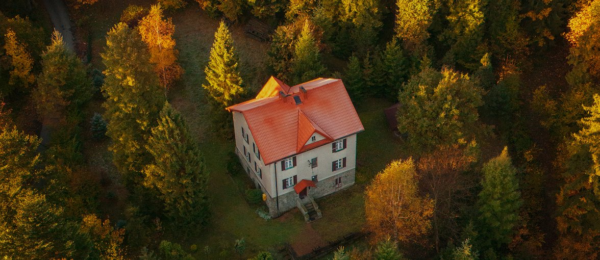 Dom wielorodzinny otoczony drzewami w jesień.