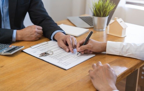 Osoba podpisująca dokumenty o kredyt hipoteczny przy umowie zlecenie w biurze banku.Blog